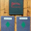 Load image into Gallery viewer, Three vintage Perrier Motor Map booklets arranged on a wooden floor: one dark green cover labeled 'Perrier Motor Map' at the top, and two blue-gray bound volumes labeled 'South Section' and 'North Section' below.
